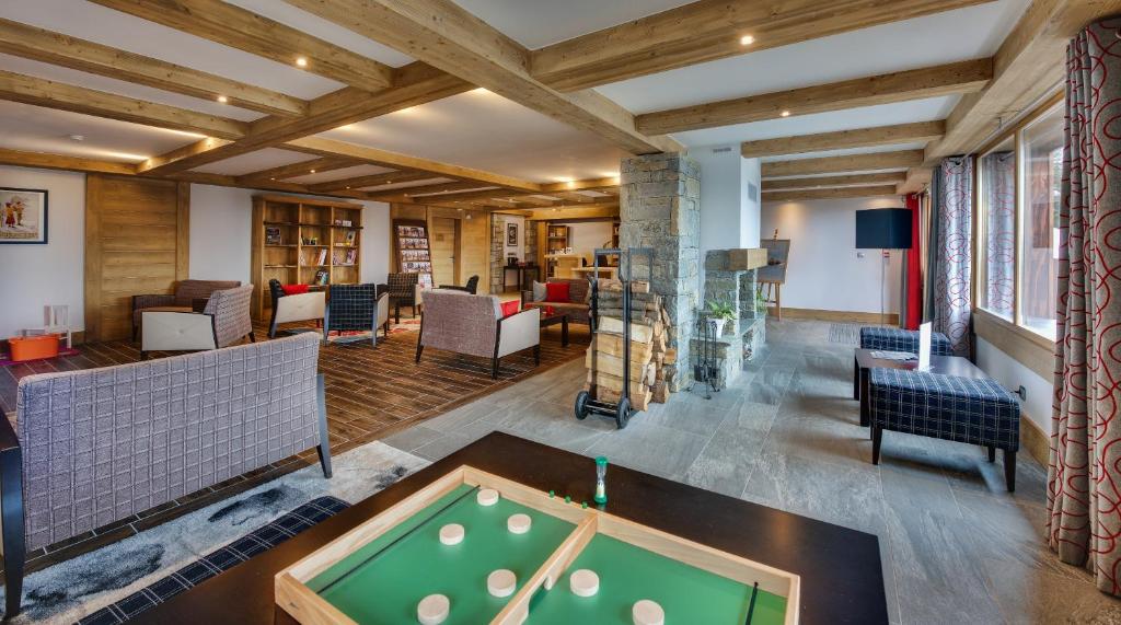a living room with a pool table and a bill at CGH Résidences &amp; Spas Chalet Les Marmottons in La Rosière
