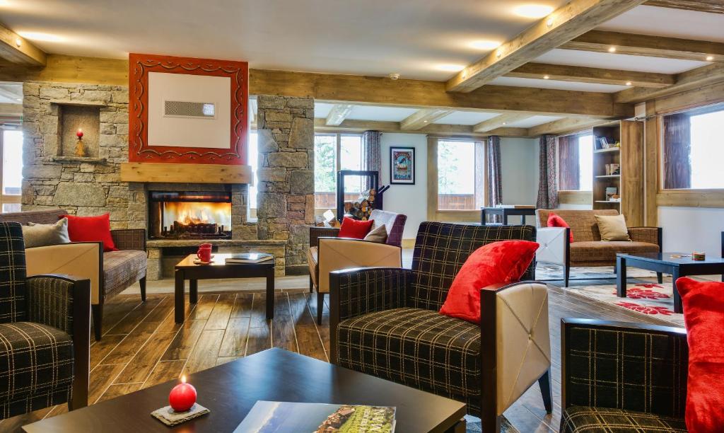 a living room with couches and a fireplace at CGH Résidences &amp; Spas Chalet Les Marmottons in La Rosière