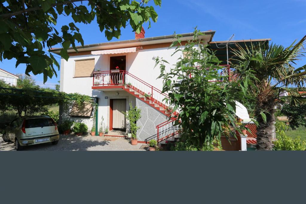 a house with a car parked in front of it at Apartment MIHAJIC M in Klimno