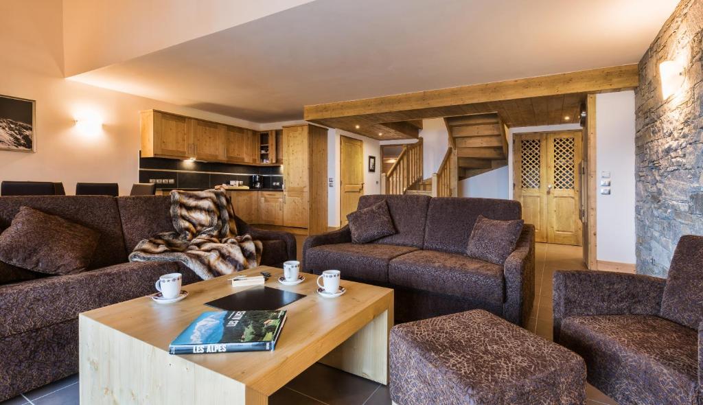 a living room with two couches and a table at CGH Résidences &amp; Spas Chalet Les Marmottons in La Rosière