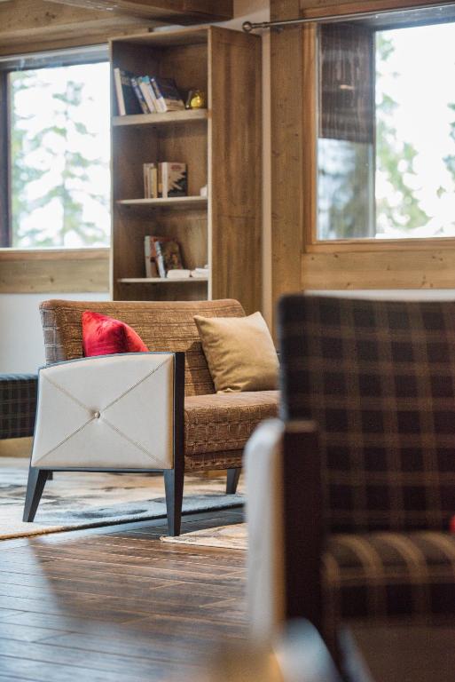 a living room with a couch and a red pillow at CGH Résidences &amp; Spas Chalet Les Marmottons in La Rosière