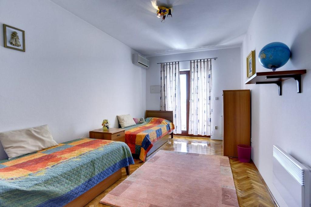 sypialnia z dwoma łóżkami i oknem w obiekcie Holiday Home Lorena w mieście Premantura