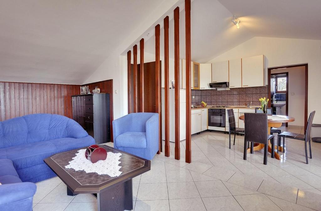 salon z niebieską kanapą i stołem w obiekcie Holiday Home Lorena w mieście Premantura