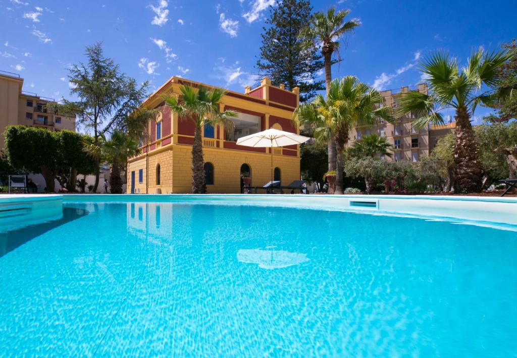 a large swimming pool in front of a house at Giardini Mon Plaisir in Trapani
