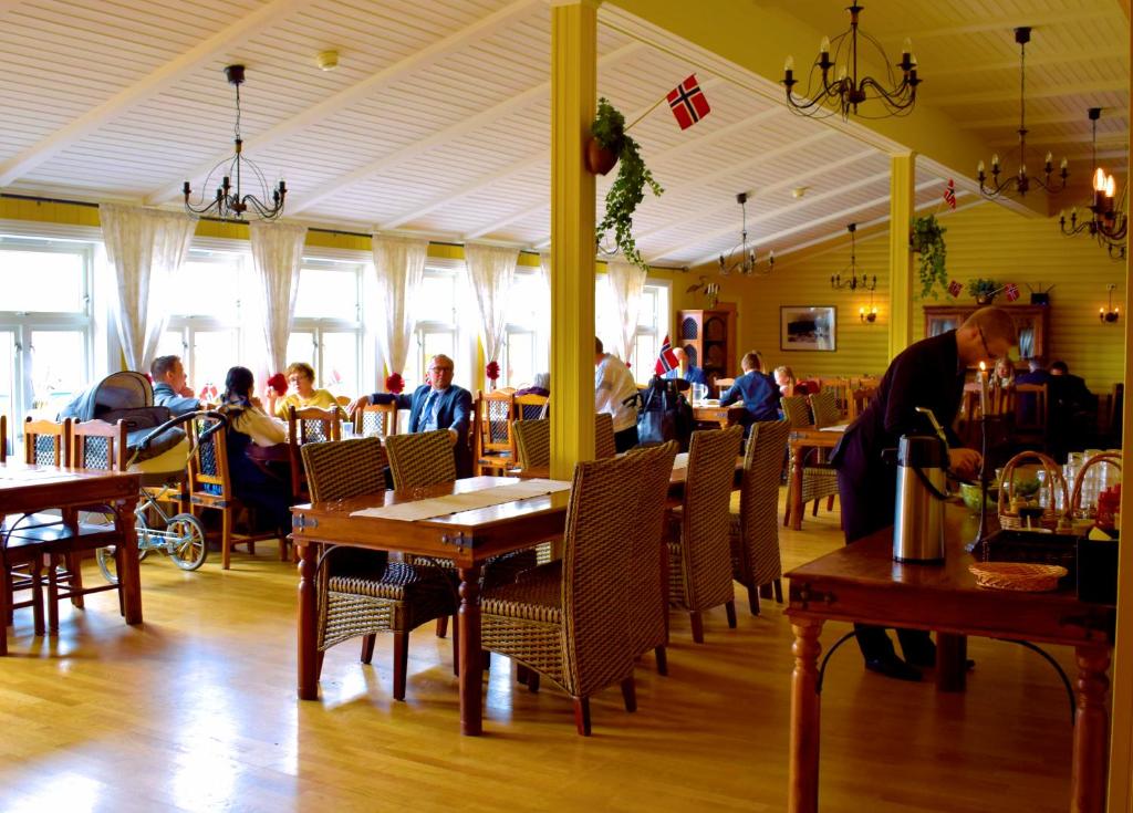 ein Restaurant mit Tischen, Stühlen und Tischen in der Unterkunft Lyngseidet Gjestegård in Lyngseidet