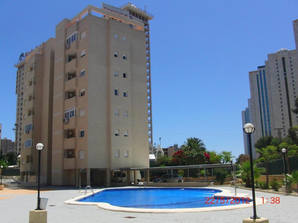 a building with a swimming pool in front of a building at Apartamentos Finestrat I-II in Cala de Finestrat