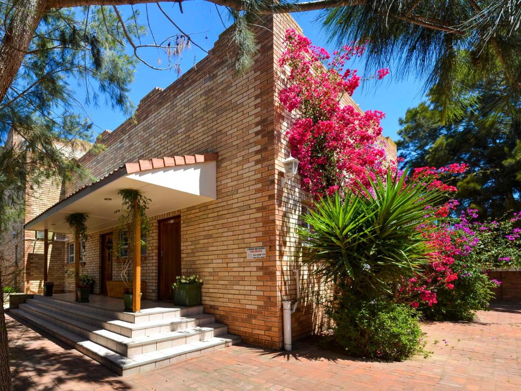 Una casa de ladrillo con flores rosas. en Sundune Guest House, en Colchester