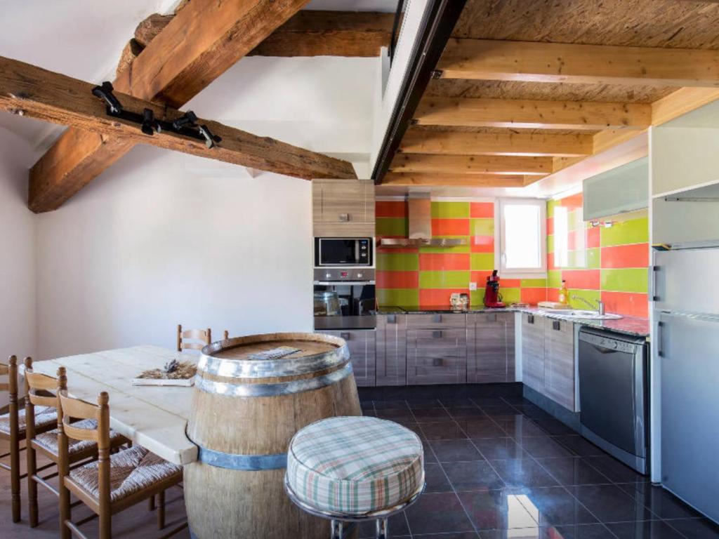 Il comprend une cuisine avec des plafonds en bois, une table et des chaises. dans l'établissement duplex sous les toits, à Palau-del-Vidre