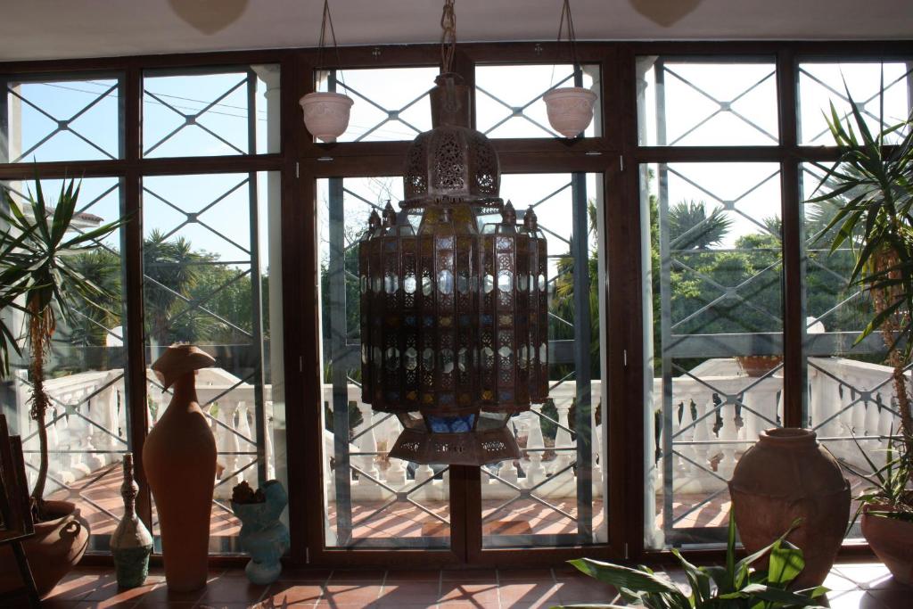 a chandelier is hanging in a room with windows at B&B LA MARCHESA in SantʼAnastasia