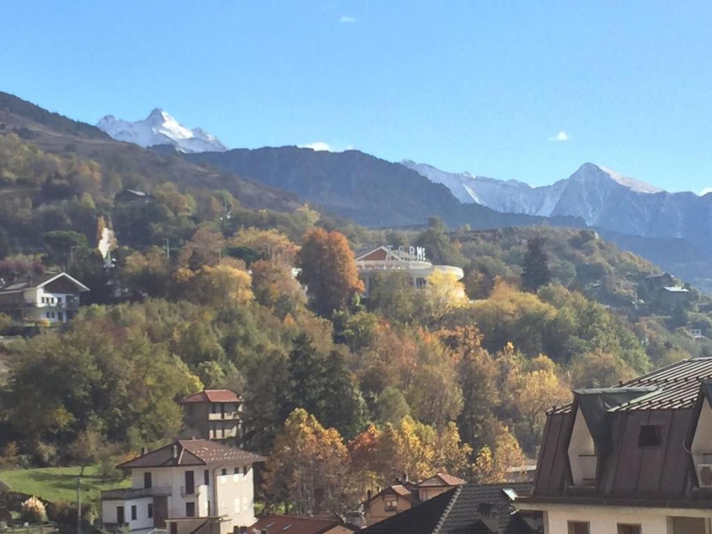 a town in the mountains with trees and houses at Stile e Tradizione in Saint Vincent