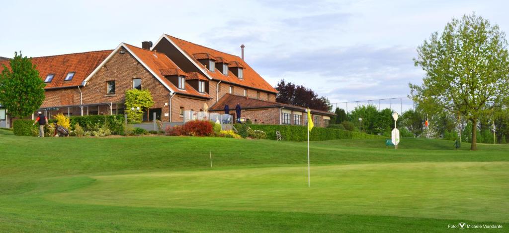 un campo da golf di fronte a una casa di Golf Hotel Mergelhof a Gemmenich