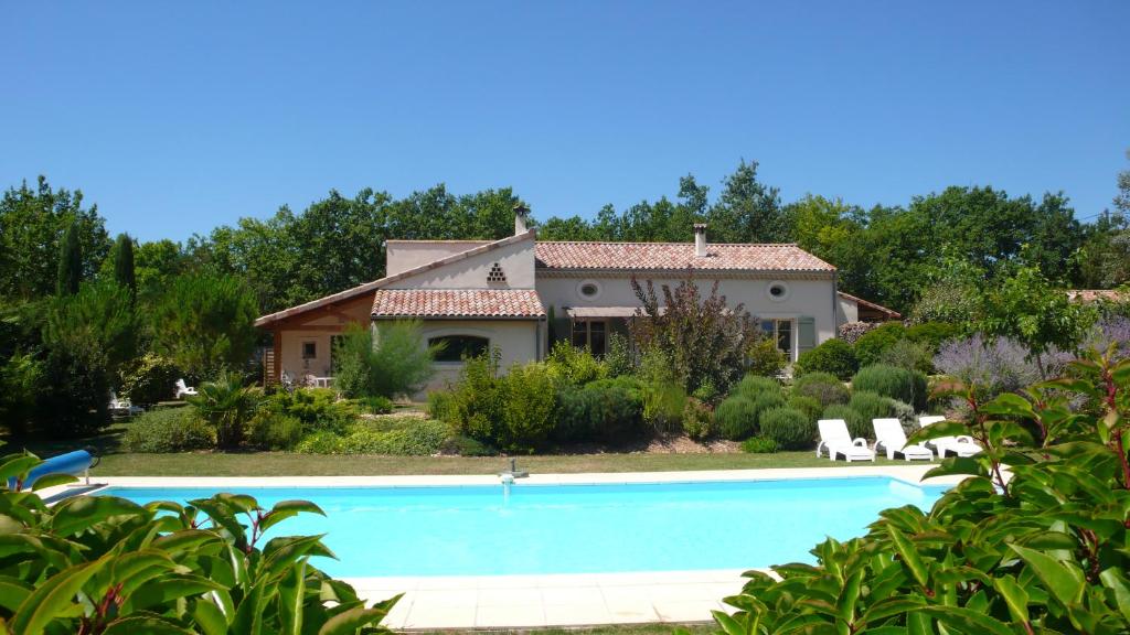eine Villa mit einem Pool vor einem Haus in der Unterkunft Gites Les Cerisiers in Blacons