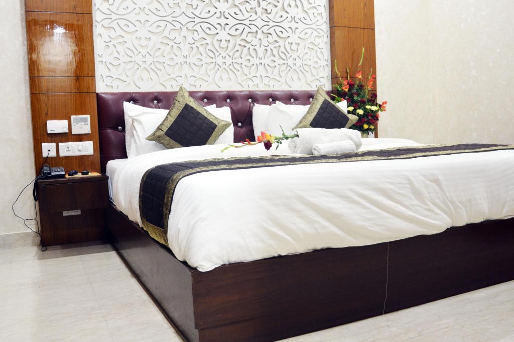 a bedroom with a large bed with white sheets at Trinity Corporate Udyog Vihar in Gurgaon