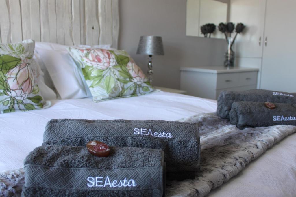 a bed with two ottomans and towels on it at SEAesta in Gansbaai