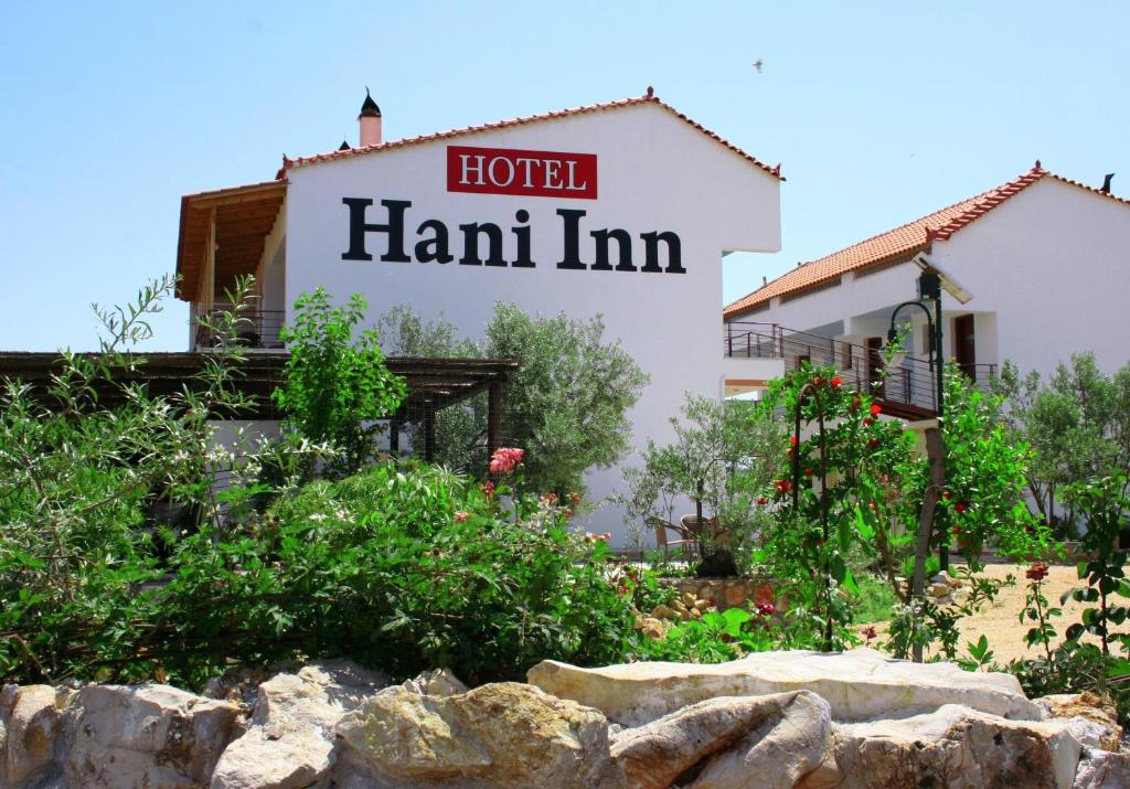 een hotelbord aan de zijkant van een gebouw bij Hani Inn in Ligourio