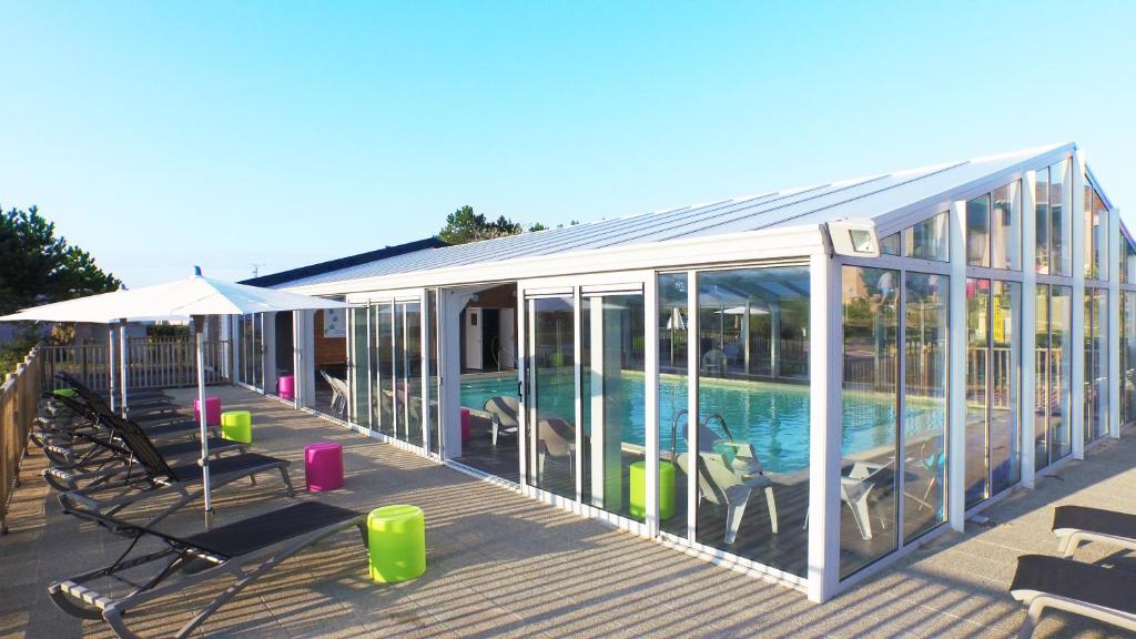 a house with a swimming pool inside of it at VVF Cotentin Îles anglo-normandes in Portbail