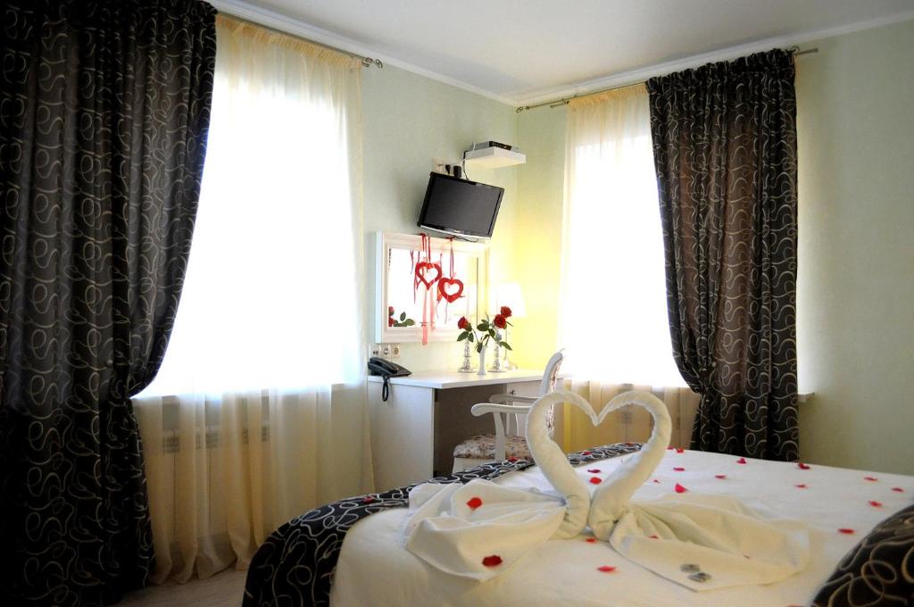 Un dormitorio con una cama con un corazón. en Avantazh Hotel, en Saratov
