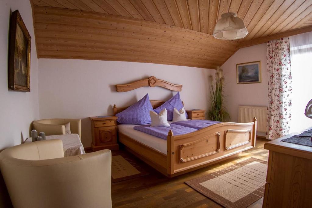 a bedroom with a bed with purple sheets and a wooden ceiling at Weingut Stoff in Kitzeck im Sausal