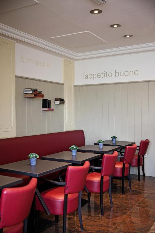 a row of tables and red chairs in a restaurant at Antwerp Harbour Hotel in Antwerp
