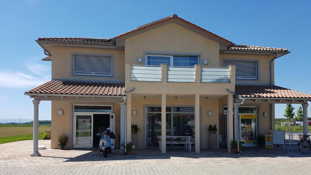 a house with a motorcycle parked in front of it at Ferienwohnungen Durgut in Ringsheim