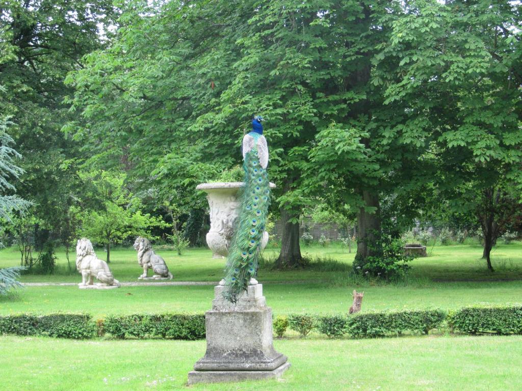 a statue of a bird in a vase in a park at Manoir de la Marjolaine in Cabourg