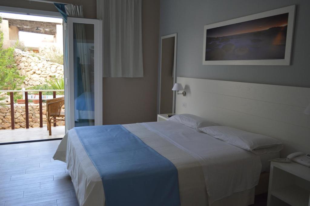 A bed or beds in a room at Le Anfore Hotel - Lampedusa