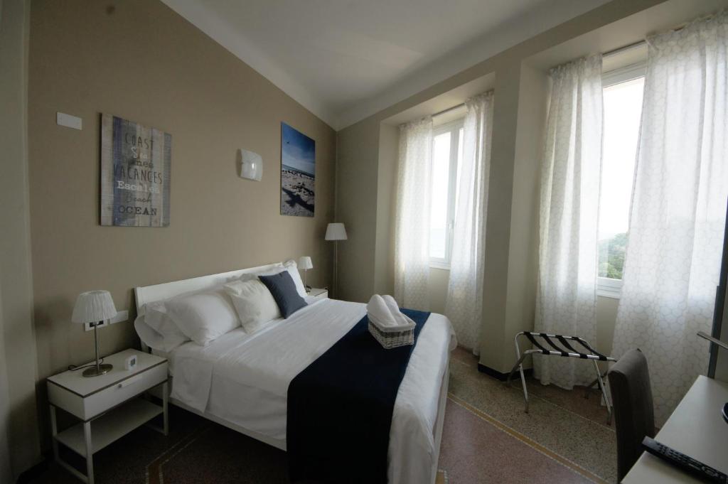 薩沃納的住宿－Luna Rooms，卧室设有一张白色大床和两个窗户。