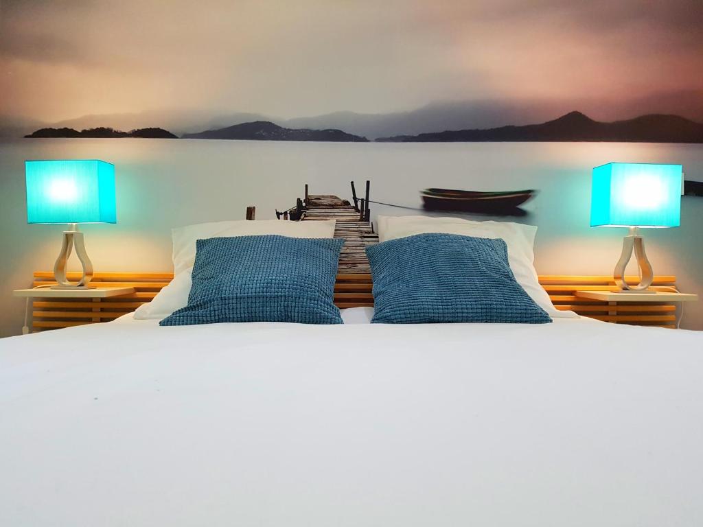 a bedroom with a bed with two lamps on it at Les Granges de Jules in Lafitte-Vigordanne