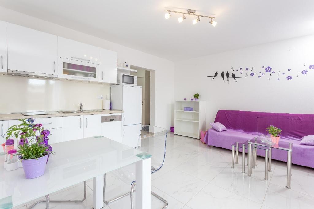 a kitchen and living room with a purple couch at Apartments Gabelic in Hvar