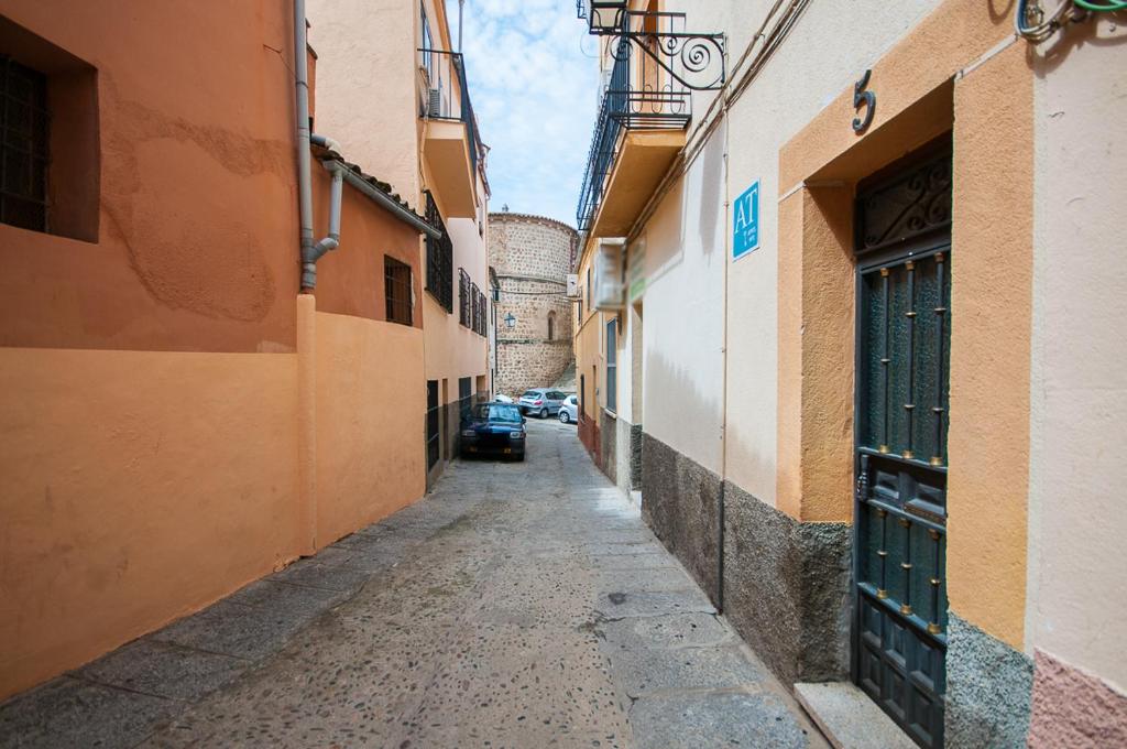 a narrow alley with a car parked in the distance at Apartamento Rincón del Salvador 2 in Plasencia