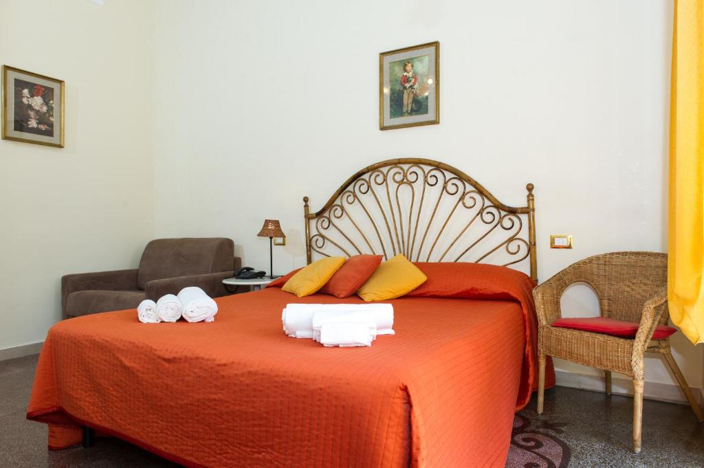 ローマにあるBoezio Houseのベッドルーム1室(大きなオレンジ色のベッド1台、タオル付)