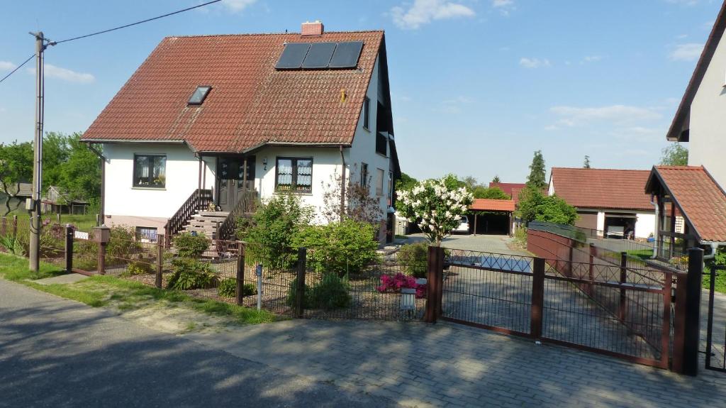 a house with a solar roof with a fence at Ferienwohnung zum Kahnfahrmann in Lübbenau