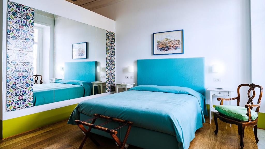 1 dormitorio con 2 camas azules y 1 silla en Donna Giulia, Luxury House, en Salerno