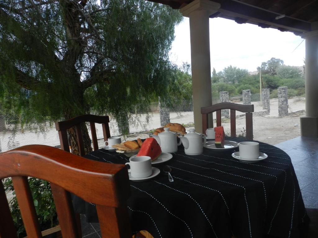 a table with a black table cloth with food on it at Los Colorados Hostal in Angastaco