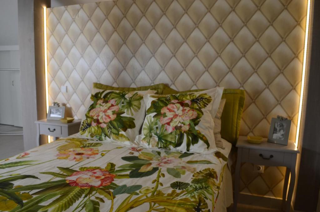 a bed with a floral bedspread and two night stands at Casa de Campo de SOUTELO in Soutelo