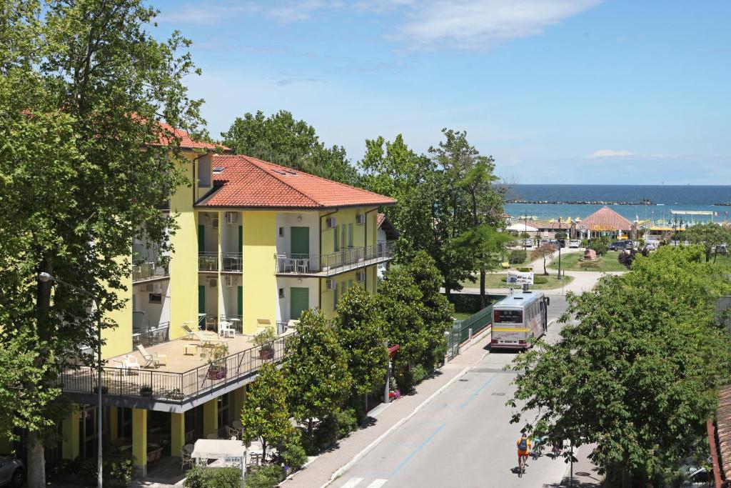 a bus driving down a street next to a yellow building at Hotel Marilinda in Cesenatico