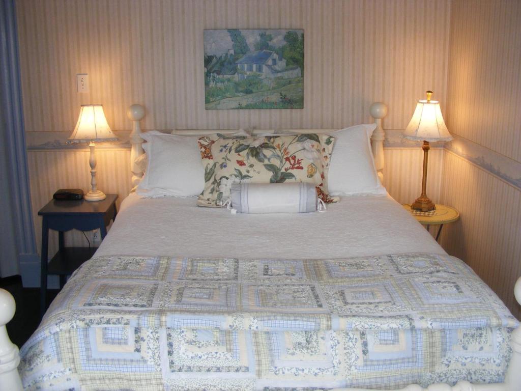 a bedroom with a large bed with two lamps at Rothesay House Heritage Inn B&B in Harbour Grace