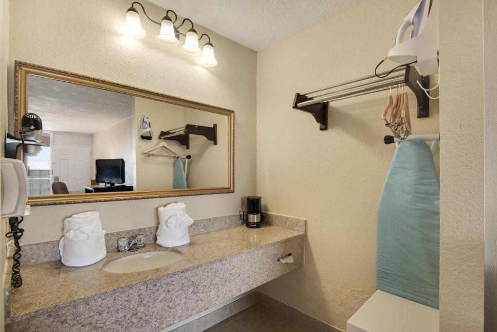 a bathroom with a sink and a mirror at Baymont by Wyndham Panama City Beach in Panama City Beach