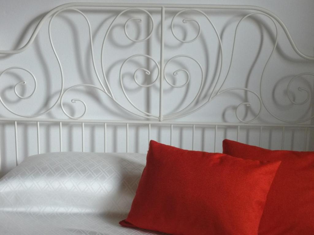 クロネにあるEridia's Roomの白いベッド(赤い枕付)が備わるベッドルームです。