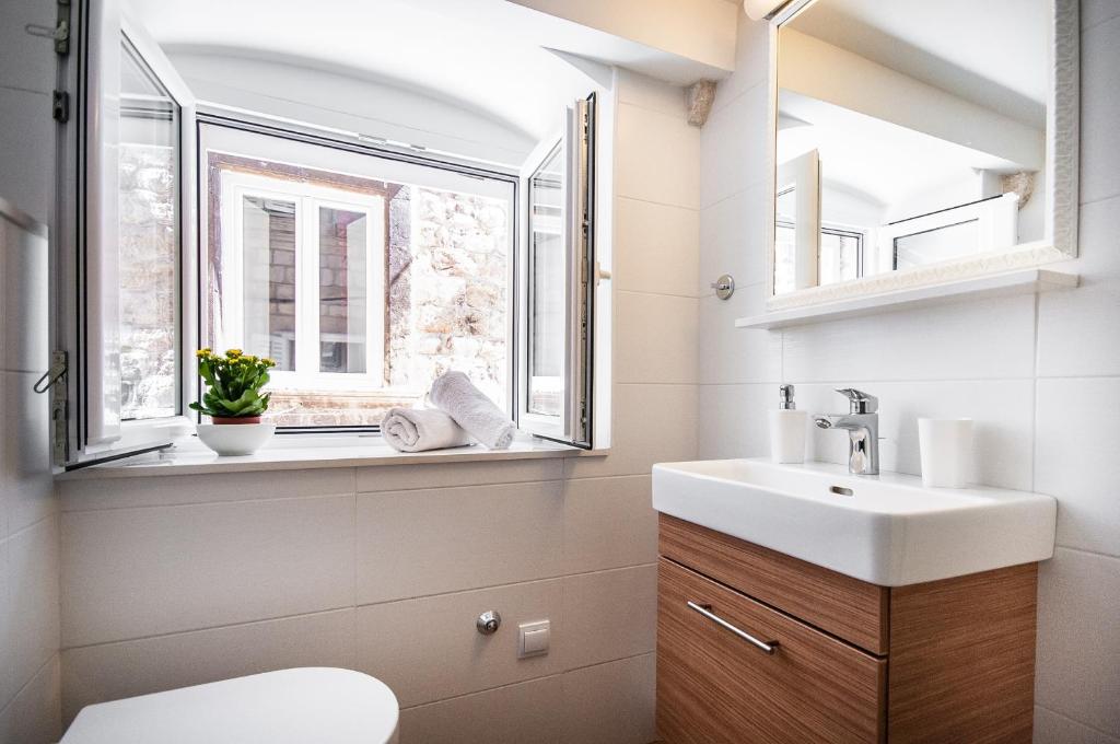 baño con lavabo y ventana en Apartments Tereza, en Dubrovnik