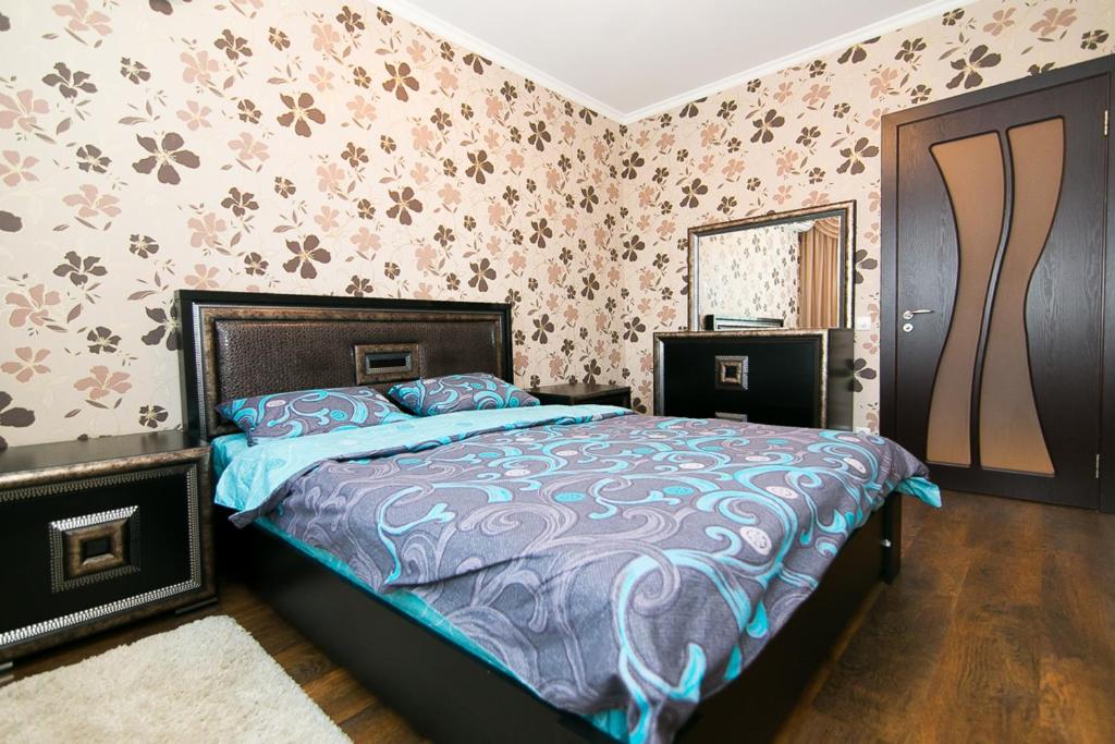 Schlafzimmer mit einem Bett und einem Spiegel in der Unterkunft VIP Apartment on Ilinska in Sumy