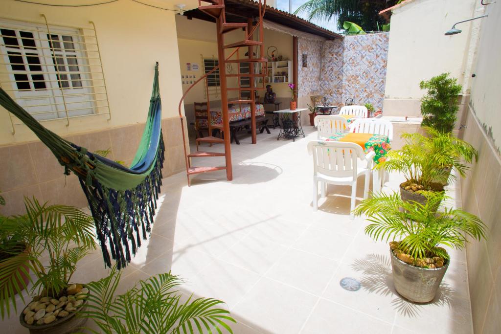 a patio with plants and a hammock on a house at Cantinho Da Del in Recife