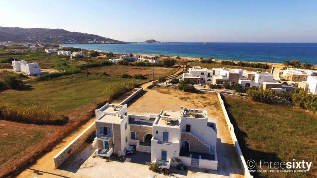 an aerial view of a white house with the ocean at Blue Harmony Apartments in Plaka