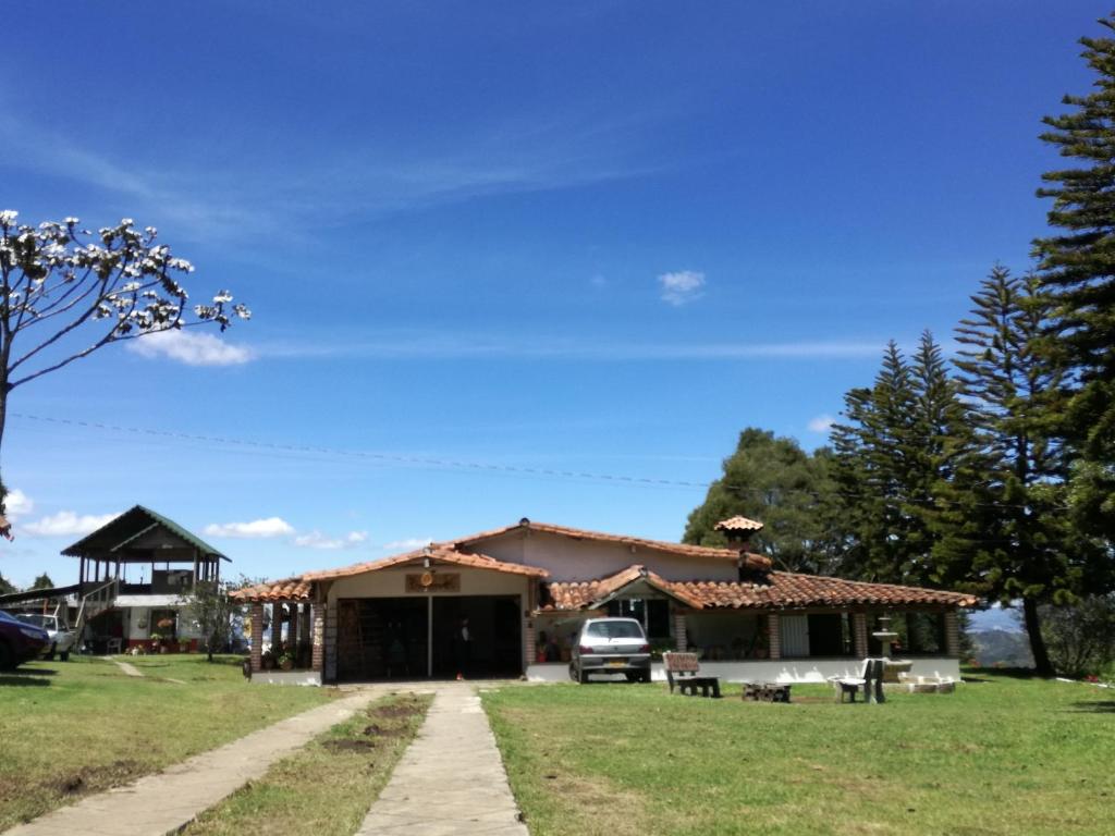 a house with a car parked in front of it at Al Bosque Hostel & Glamping in Santa Elena