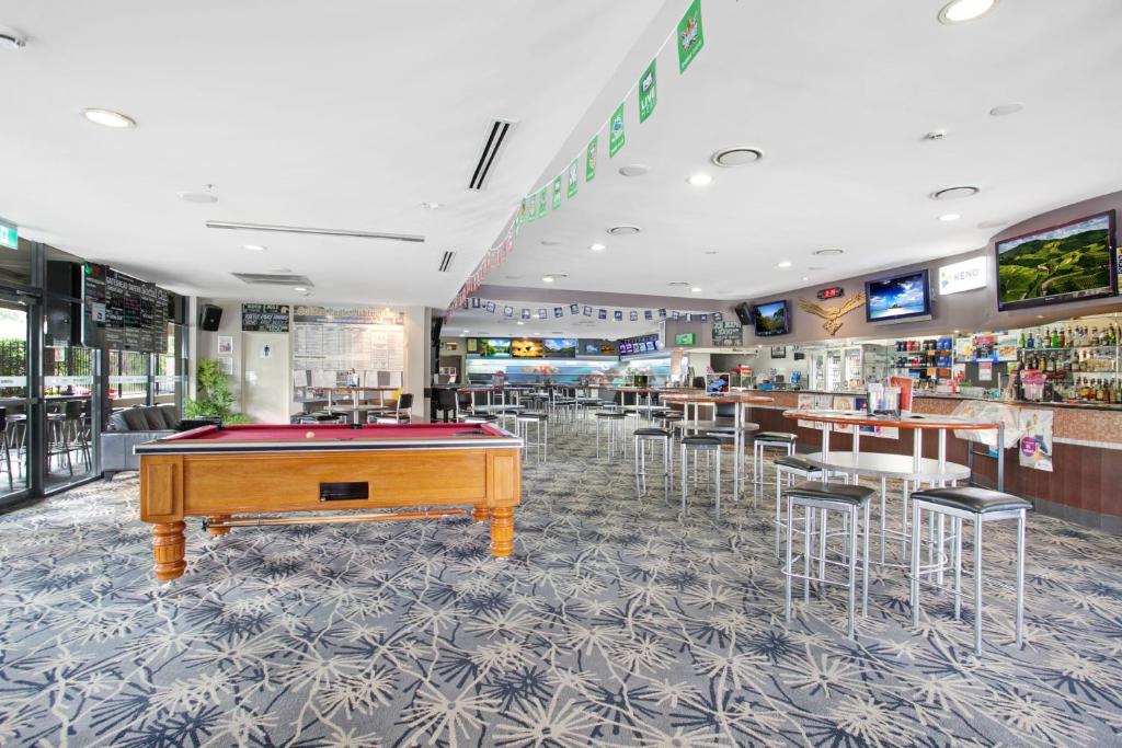 a restaurant with a pool table in the middle of the room at Gateshead Tavern & Motel in Charlestown