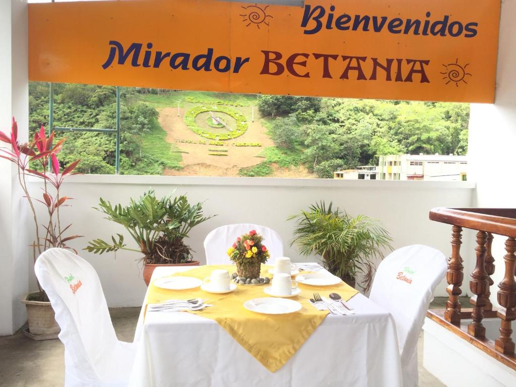 a table with white chairs and a sign that readsinator berium at Hotel Betania in Zamora