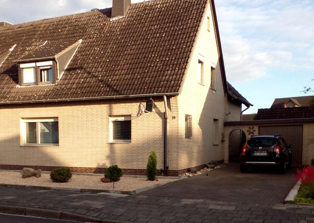 une maison avec une voiture garée devant elle dans l'établissement Monteurwohnung Maier, à Dormagen
