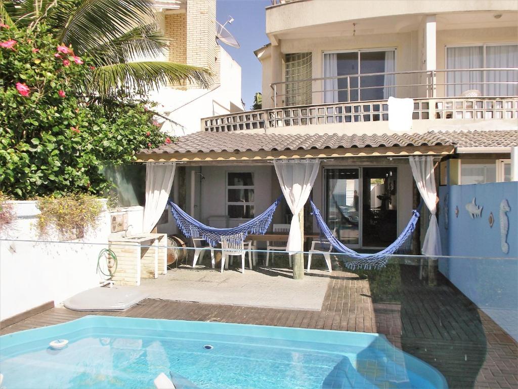 uma villa com uma piscina e uma casa em Casa Beira Mar em Bombinhas