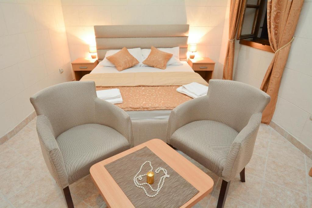 sypialnia z łóżkiem, 2 krzesłami i stołem w obiekcie Apartments Casa di Cattaro w Kotorze