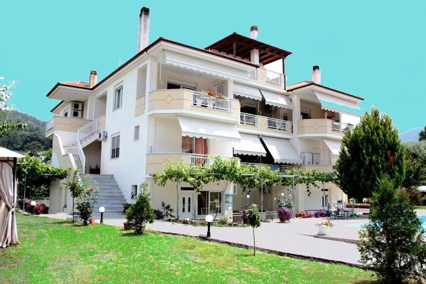 un gran edificio blanco con césped delante en Villa Valeria Thassos, en Limenas